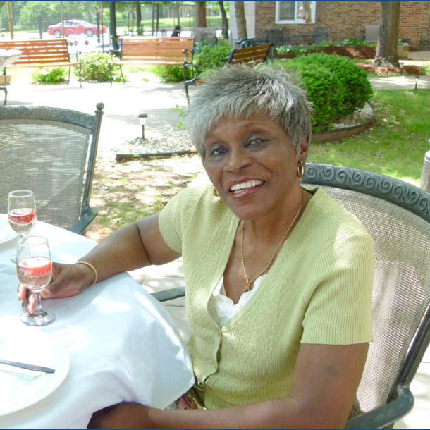 Woman enjoying patio at Tower Grove community