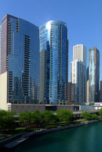 Chicago buildings on river against blue sky
