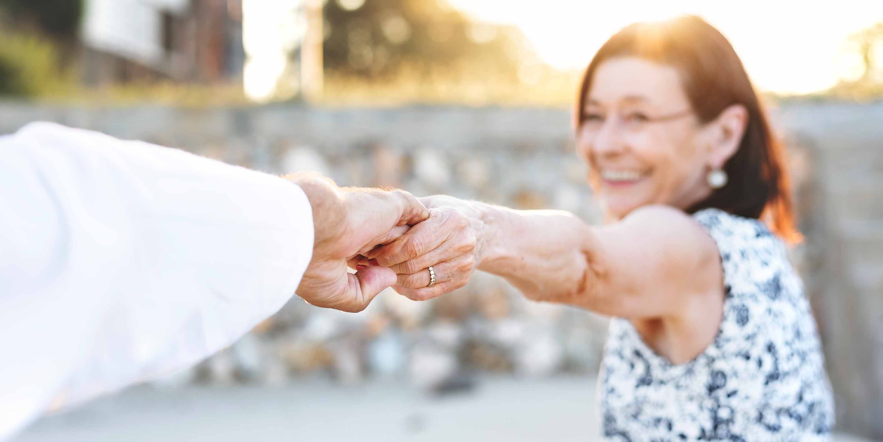 Woman holding hand making way toward sun