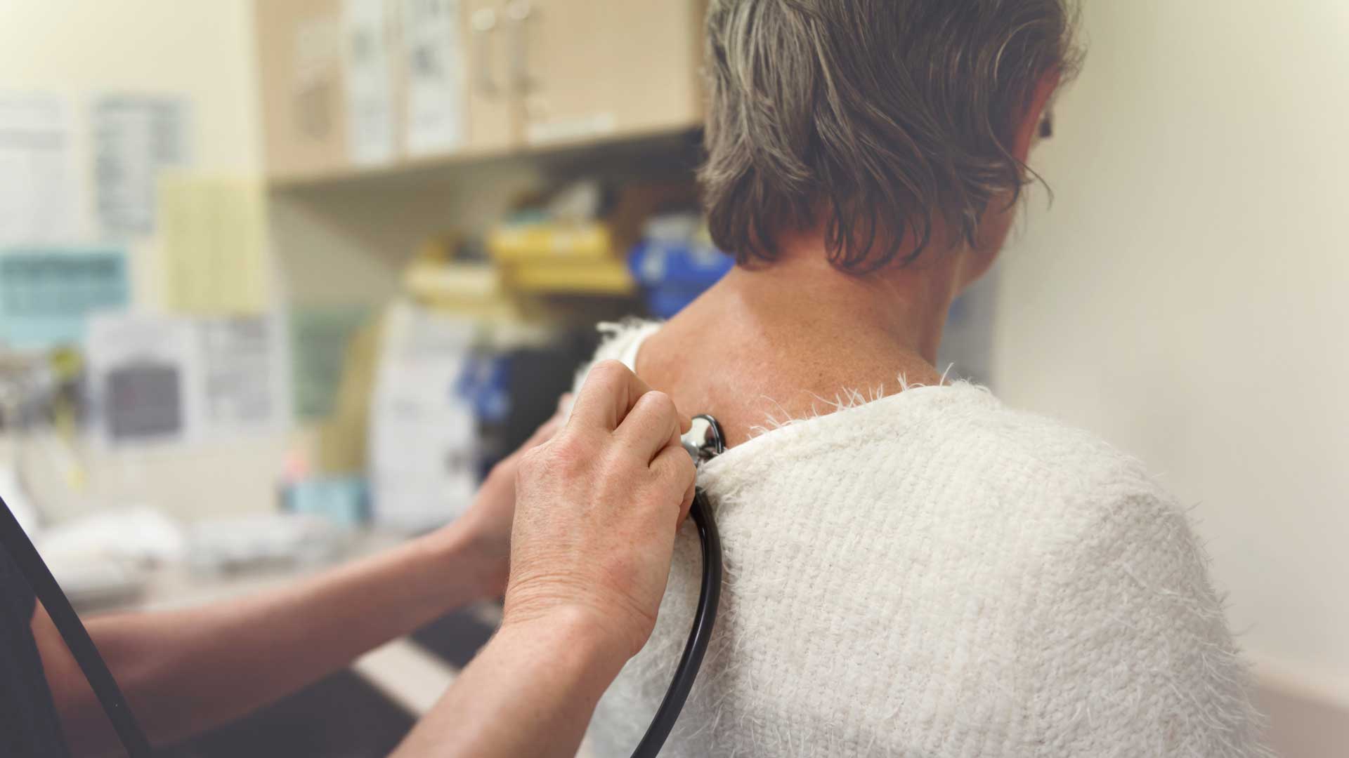 healthcare-for-all-cover Woman being evaluated with stethoscope