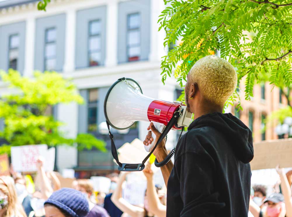Man with megaphone speaking to crowd
