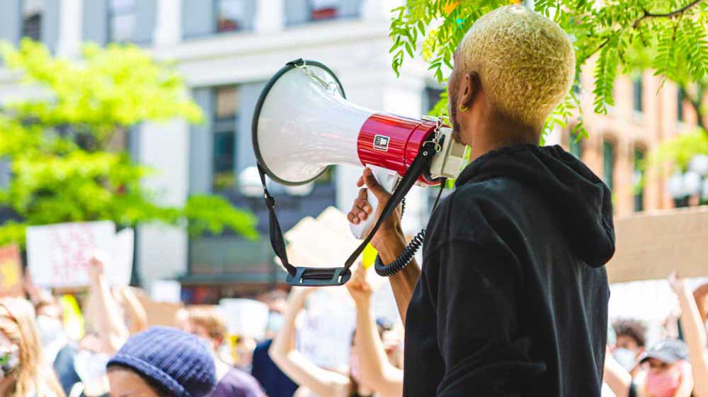 Man hold megaphone in front of crowd